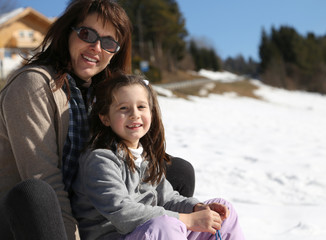 mom and girl in winter on sledge