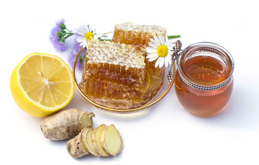 honeycomb, ginger, lemon, chamomile, honey in a glass jar on a w