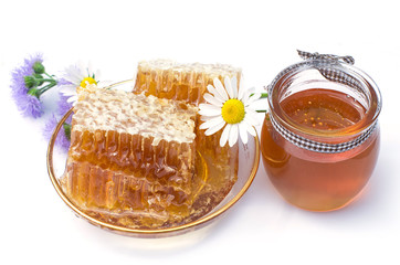 honeycomb, chamomile, honey in a glass jar on a white background