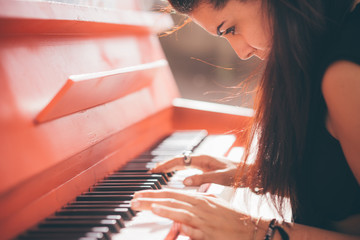 Young beautiful caucasian girl playing piano
