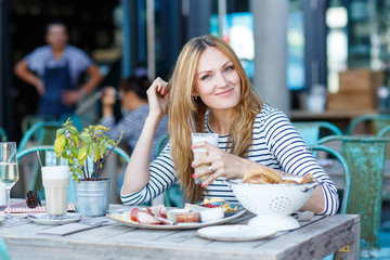 Young woman having healthy breakfast in outdoor cafe
