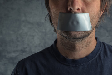 Censorship concept, man with duct tape on mouth