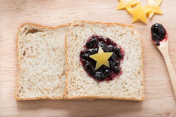 Bread with bluberry jam on wood, top view