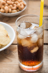 Cold cola iced drink in a glasses on a  wood background.