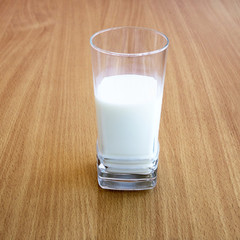 A fresh cold milk in high transparent glass. Let us eat cake with milk.
