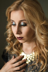 A woman in a gold necklace. Closeup portrait.