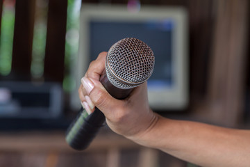 Old black microphone in hand, depth of field