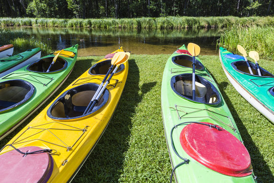 Colorful fiberglass kayaks tethered to a dock as seen from above