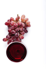 Red wine and grapes overhead on white