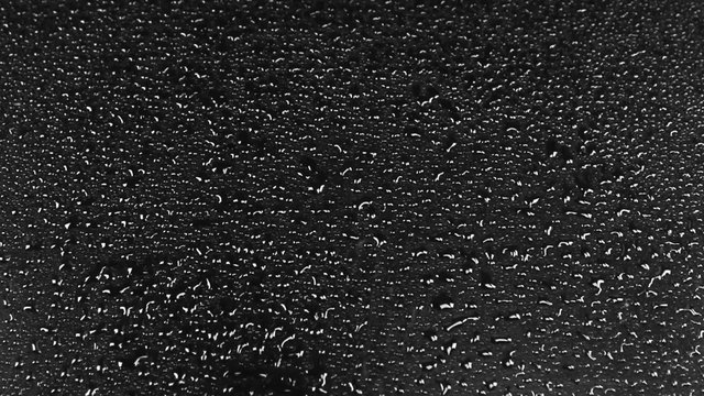 
Drops of water falling on a black background, approximation, top view
