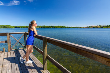 Fototapeta na wymiar Girl enjoy summer landscape on sea bridge