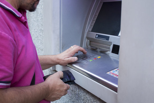 Hombre sacando dinero de un cajero autom&aacute;tico