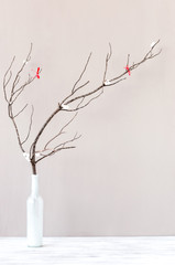 Bare branch in white vase on table top, interior decoration