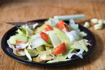 heap of rotten food waste closeup on a black plate