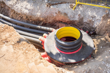 Excavation pit, electrical cables and optical fibres in the digging on a construction site