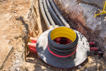 Excavation pit, electrical cables and optical fibres in the digging on a construction site