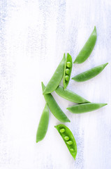 Fresh green peas on rustic white background