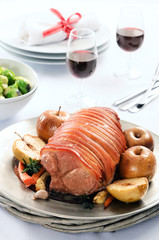 Roast pork with apple on a table set for celebration