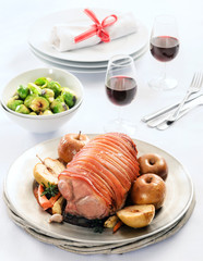 Roast pork with apple on a table set for celebration