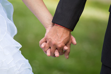Young married couple holding hands, ceremony wedding day