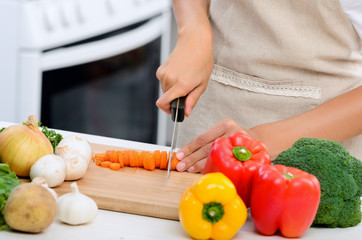 Hands holding knife cutting vegetables