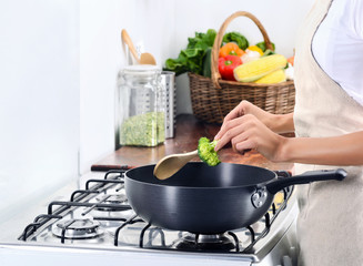 Woman standing by stove cooking and preparing meal