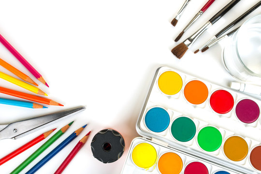 Deckfarbkasten, Pinsel und Buntstifte auf hellem Hintergrund in Draufsicht mit Textfreiraum