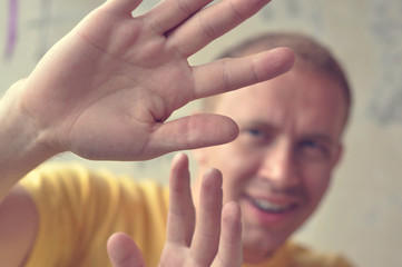 Closeup portrait of stunned young man raising hands in front to say no!
