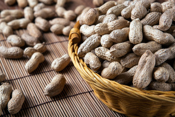 large grains of peanuts in the shell and basket