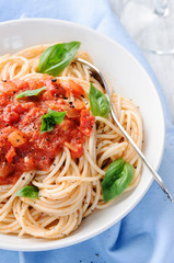 Spaghetti with red tomato sauce and basil garnish