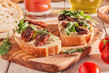 Sandwich with mozzarella, sun-dried tomatoes and arugula.