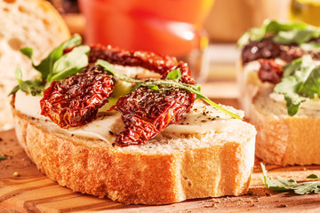 Sandwich with mozzarella, sun-dried tomatoes and arugula.