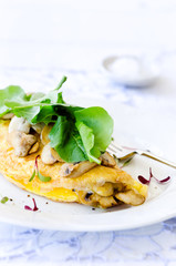 Omelette folded with mushrooms and fresh rocket