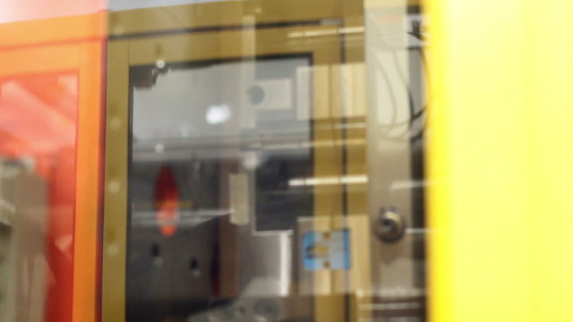 Close up of the mold of an injection molding machine making plastic parts in a factory

