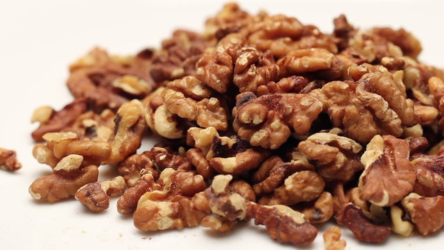Heap of walnut kernels isolated on white, rotating 