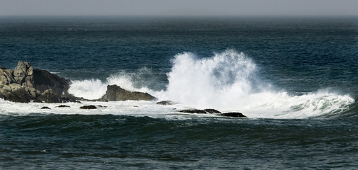 Wave crashes onto rocks on storm day
