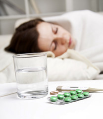 Obraz na płótnie Canvas girl lying near sick medicines
