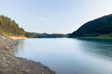  Clear mountain lake and rocky mountains in late summer.