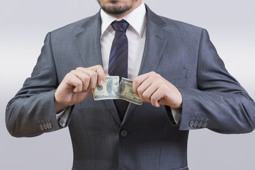 Businessman tearing up a dollar bill