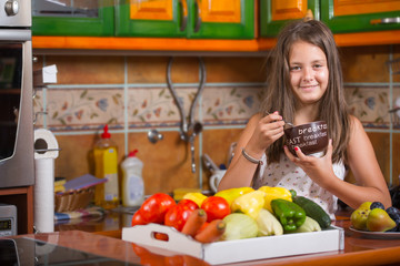 Cute little girl having breakfast in the kitchen