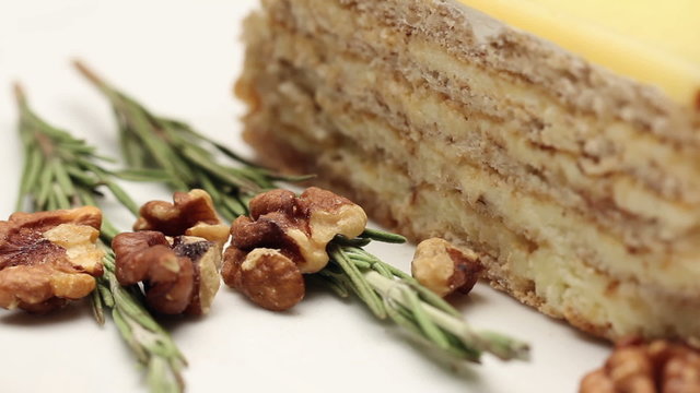 Close up of a walnut cake with vanilla fondant on white plate, rotating