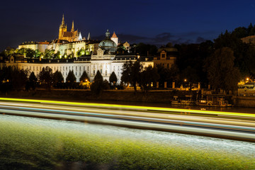 Prague castle in Hradcany with Vlatava river and lights from boats