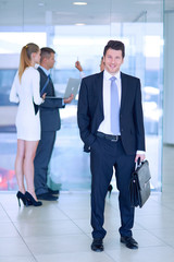 Portrait of young businessman in office with colleagues in the