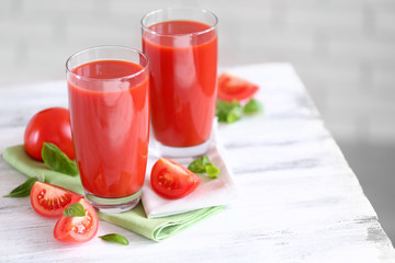 Tomato juice and fresh tomatoes on wooden table close-up