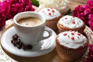 Composition with cup of coffee, muffins and peony flowers on tray, on wooden background
