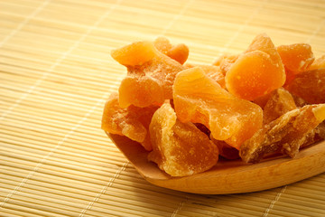 Closeup candied ginger on wooden spoon