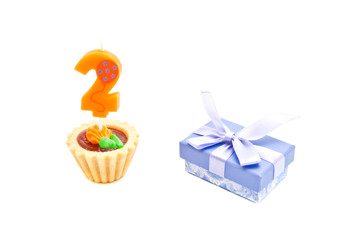 cake with two years birthday candle and gift on white