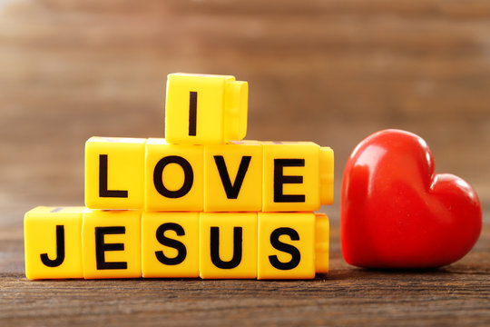I LOVE JESUS sign illustrated with yellow plastic letters on wooden background