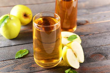 Glasses of apple juice on wooden background