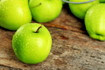 Ripe green apples on wooden table close up